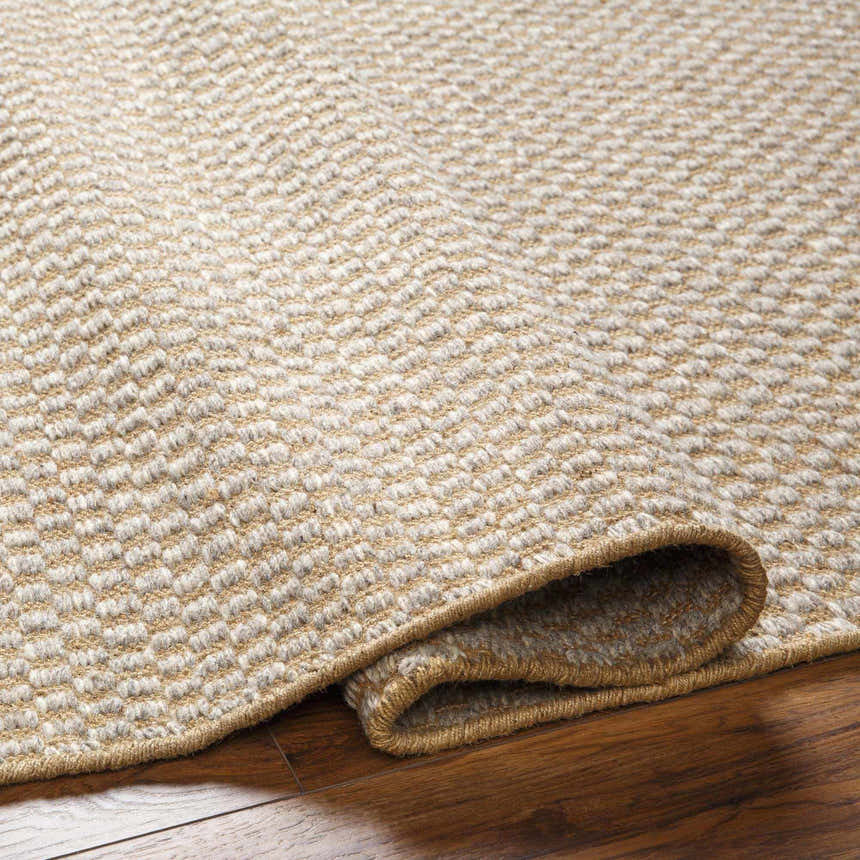 Close-up of the hand-woven Ayers Beige & Gray Area Rug showing its jute and wool texture and geometric pattern. Fold