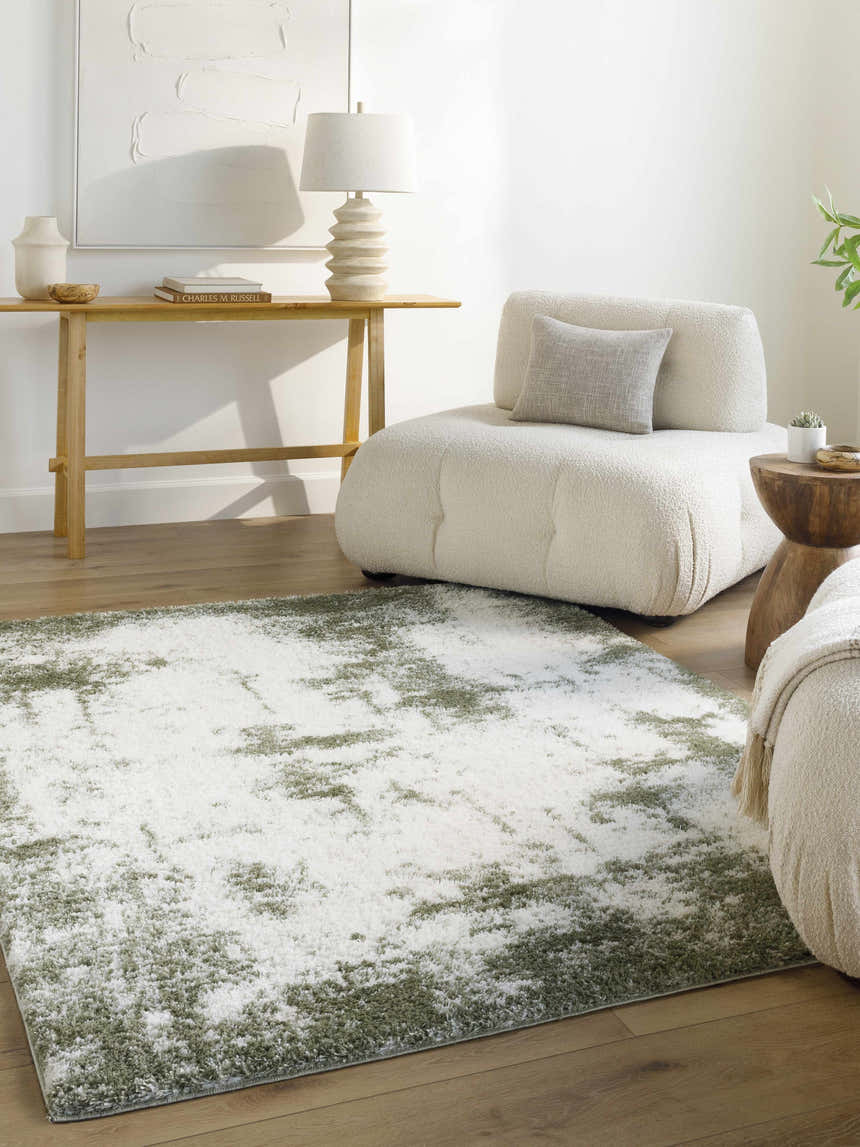 Living room scene with a beige sofa and the Jioni Area Rug, a white shag rug with a subtle green pattern. Roomscene-Square