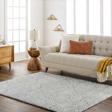 Living room scene with a beige couch and the gray geometric Mura Area Rug on a dark wood floor. Roomscene-Rectangle