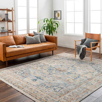 Living room scene with a camel leather sofa and the Bora Area Rug in camel, copper, and blue. Roomscene-Rectangle