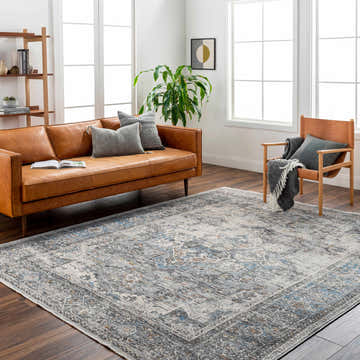 Living room scene with a clay leather sofa and Erela Area Rug in clay, dark gray, and light gray tones. Roomscene-Rectangle