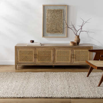 Living room scene with a beige Mitzy Area Rug, wood console table, and woven chair. Roomscene-Rectangle