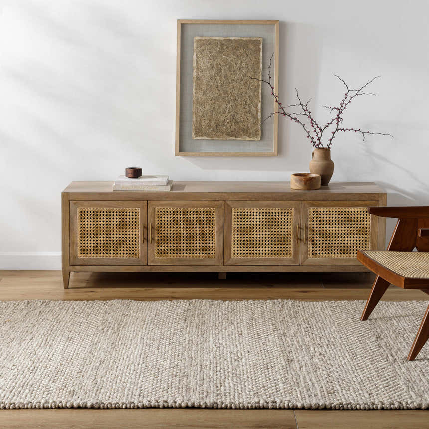 Living room scene with a beige Mitzy Area Rug, wood console table, and woven chair. Roomscene-Rectangle