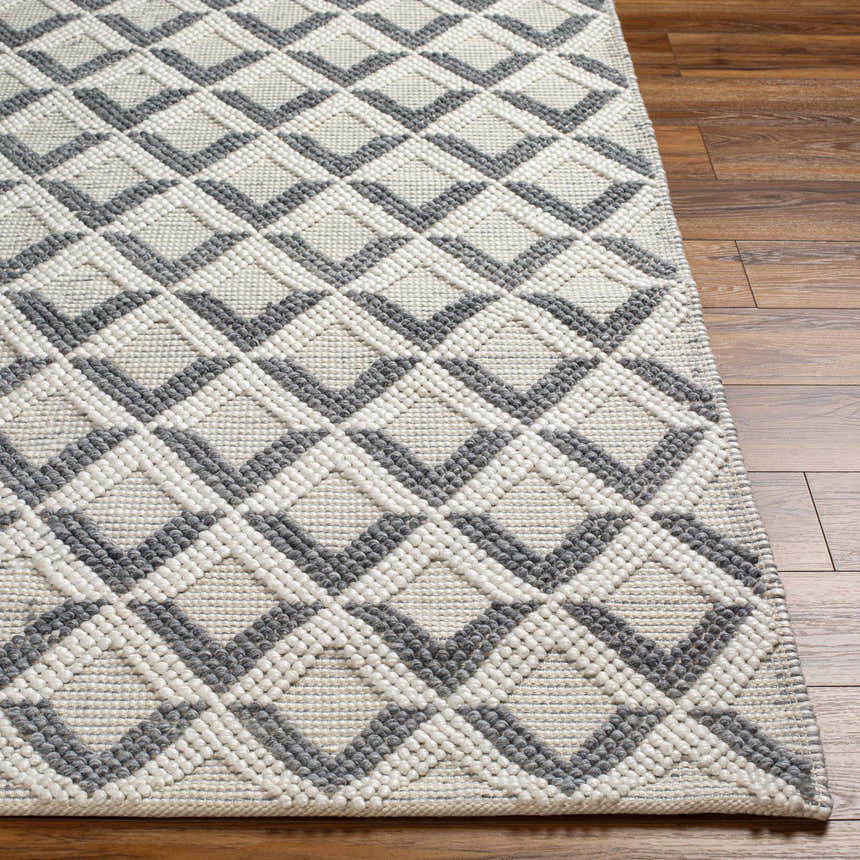 Close-up of the hand-woven Maik Area Rug. Dark gray geometric diamond pattern on light gray recycled PET yarn. Farmhouse style. Front