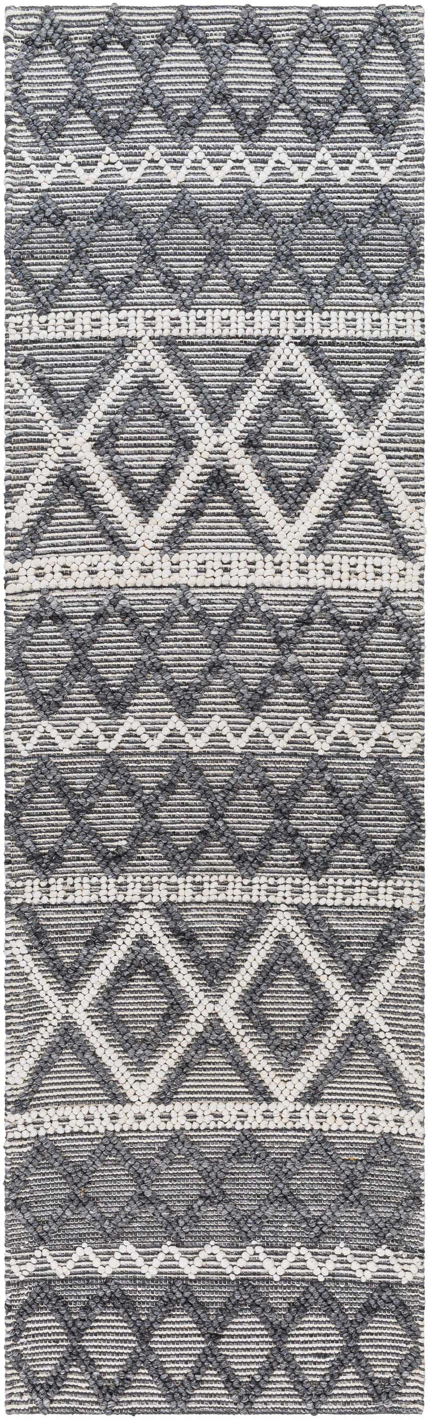 Close-up of the Yuka Area Rug. Hand-woven rug with a geometric diamond pattern in dark gray and natural gray. Design-Runner-268