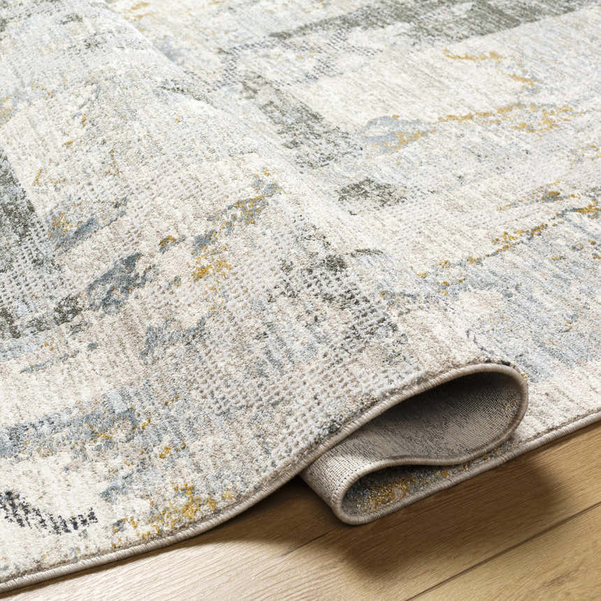 Close-up of the textured Adlai Rug. Colors include off white, gray, blue, and mustard. Contemporary style. Fold