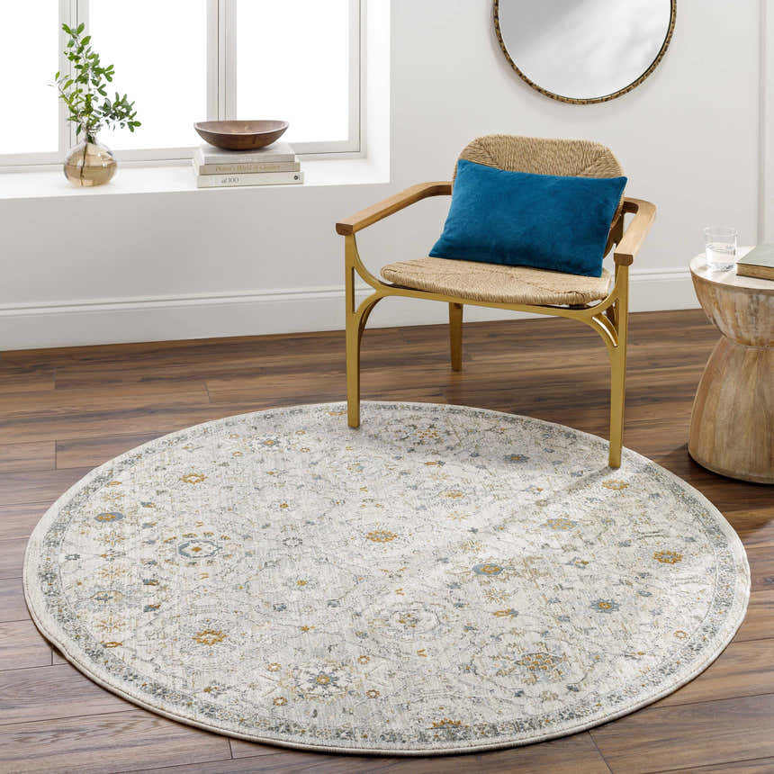 Light-filled room with round Annie Cream Textured Rug, wood floors, and a stylish chair with a blue pillow. Roomscene-Round