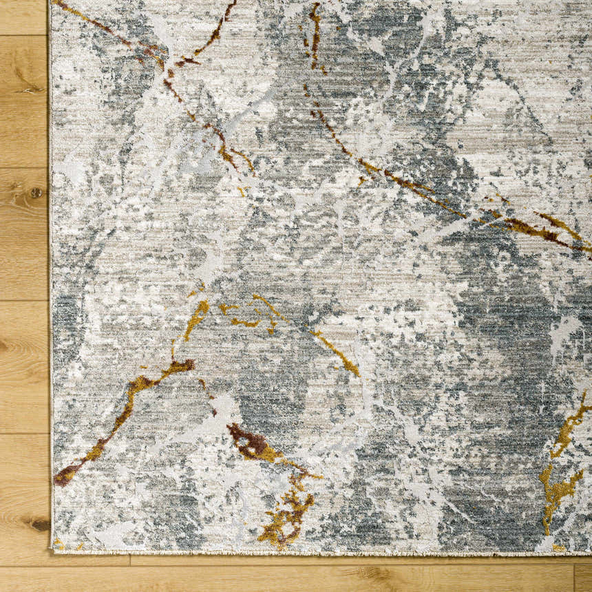 Close-up of the Asena Textured Rug. Abstract design with gray, caramel, and brown tones. Machine woven polyester rug. Corner
