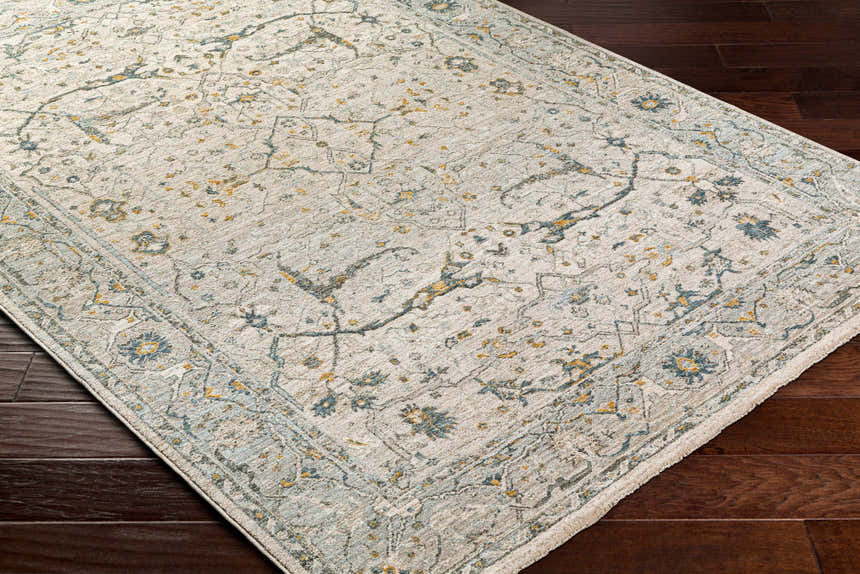 Close up of Aviva Off-White Textured Rug. Farmhouse style rug with dusty sage, light gray, and mustard floral pattern. Corner