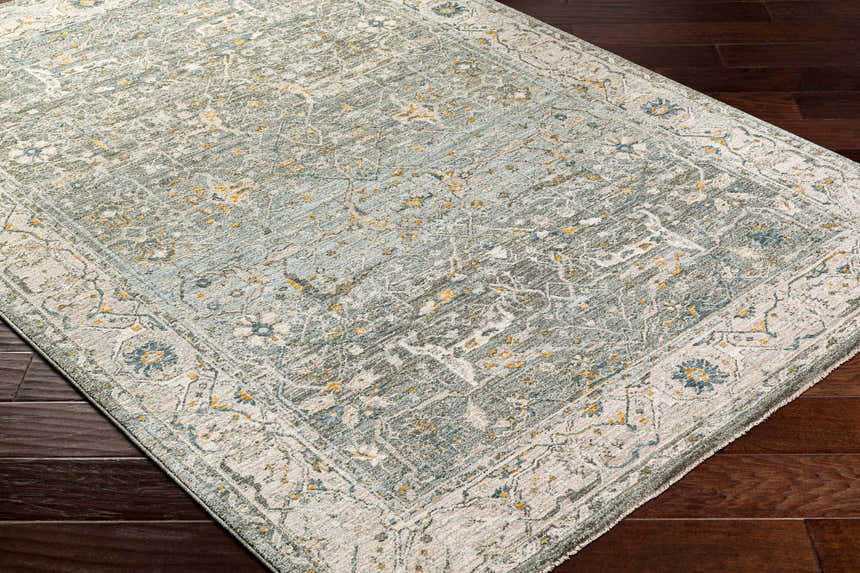 Close-up of Aviva Teal Textured Rug showing its traditional pattern, teal, gray, and mustard colors, and textured weave. Corner