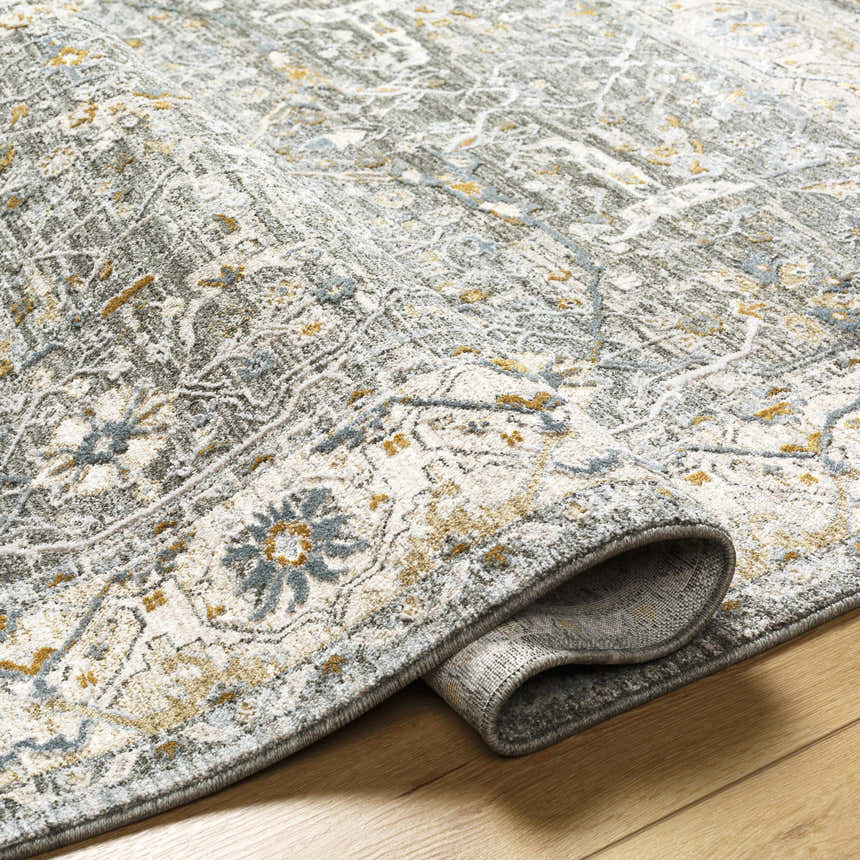 Close-up of textured Aviva Teal Rug. Features dusty sage, light gray, mustard, and off-white traditional pattern. Fold