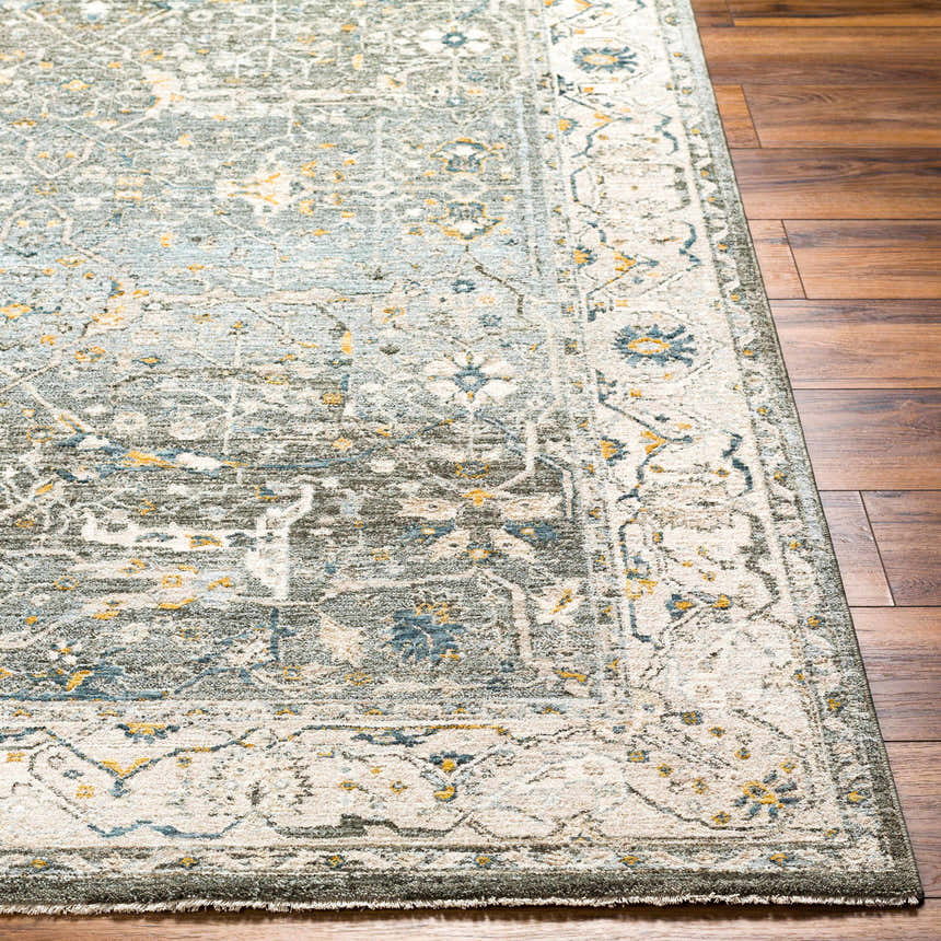Close-up of the Aviva Teal Textured Rug with Fringes showing its traditional pattern and colors on a dark wood floor. Front