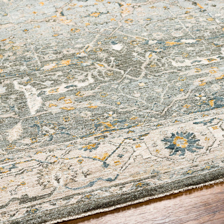 Close-up of the Aviva Teal Textured Rug showing its traditional floral design and textured weave. Colors include teal, mustard, and gray. Texture