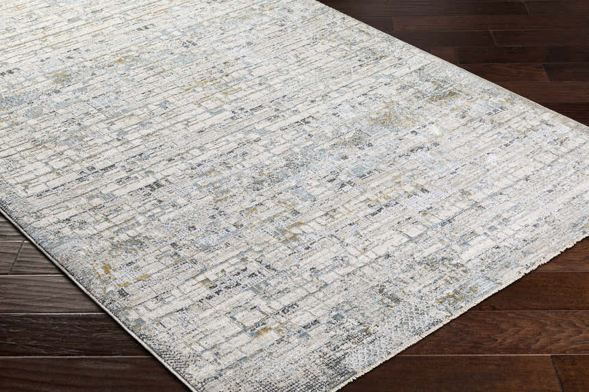 Close-up of the Chaka Textured Rug in off white, light gray, teal, and mustard on a dark wood floor. Corner