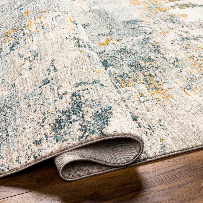 Close-up of the Chaya Textured Abstract Rug, showing its dusty sage, ink blue, and mustard colors, plus textured design. Fold