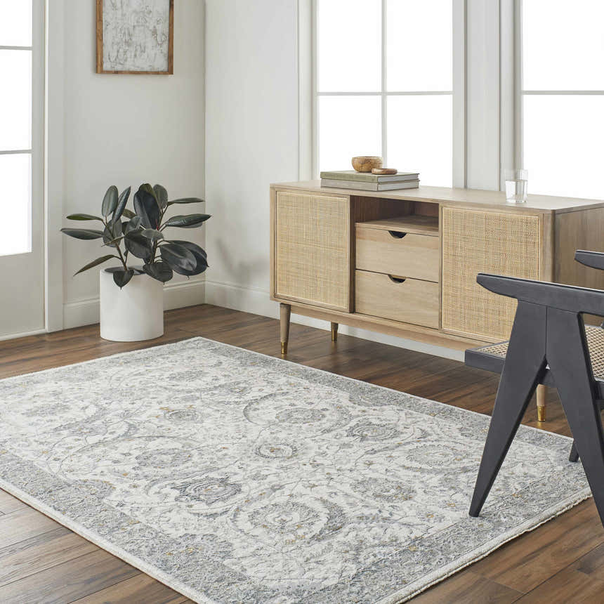 Living room scene with a Gauge Cream & Gray Blue Rug, wood floors, rattan cabinet, and modern black chair. Roomscene-Rectangle