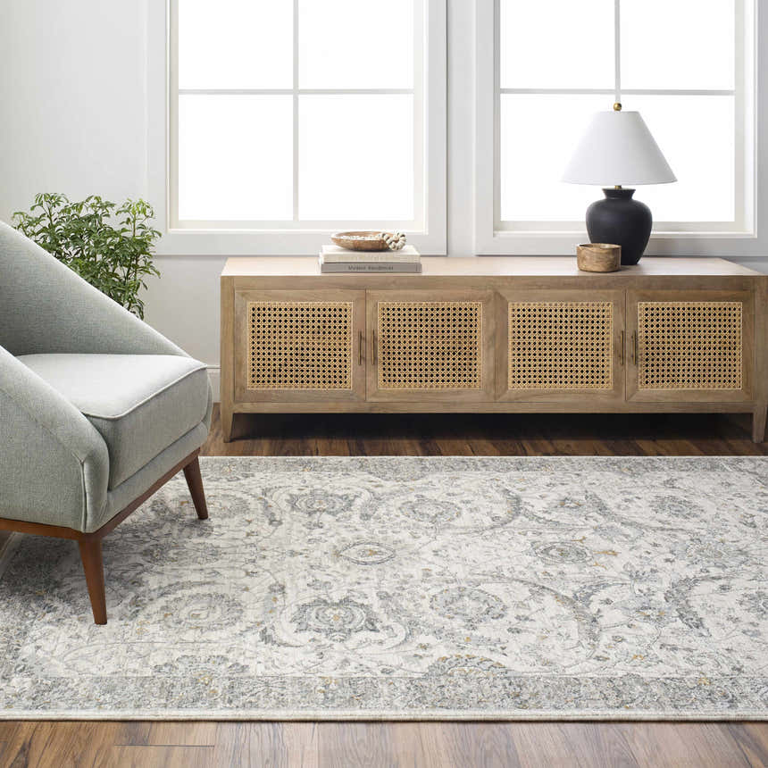 Living room scene with a Gauge Cream & Gray Blue Rug, gray chair, wood cabinet, and natural light. Roomscene-Rectangle