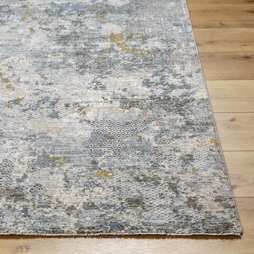 Close-up of the Pizi Textured Rug. Features dusty sage, ink blue, light gray, and mustard hues with a subtle textured pattern. Front