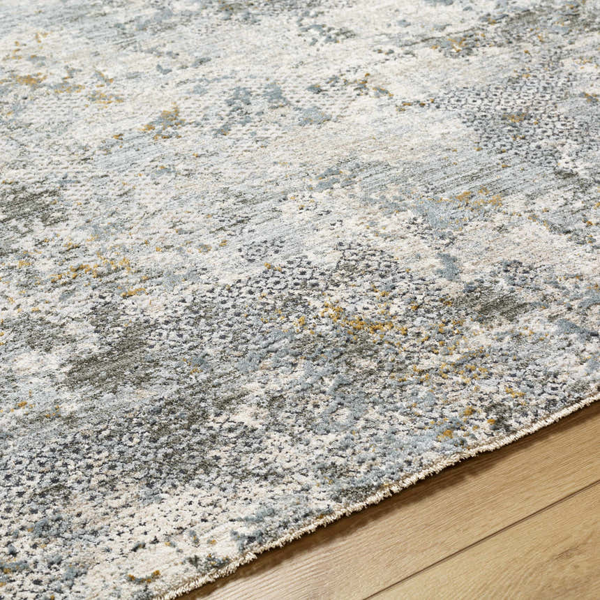 Close-up of the Pizi Textured Rug with Fringes. Features dusty sage, light gray, and mustard hues. Machine woven polyester. Texture