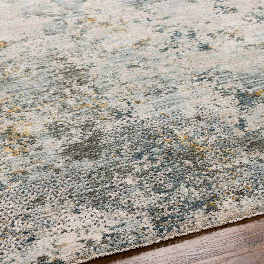 Close-up of the Pizi Textured Rug, showcasing its abstract design in dusty sage, ink blue, and mustard on a wood floor. Texture