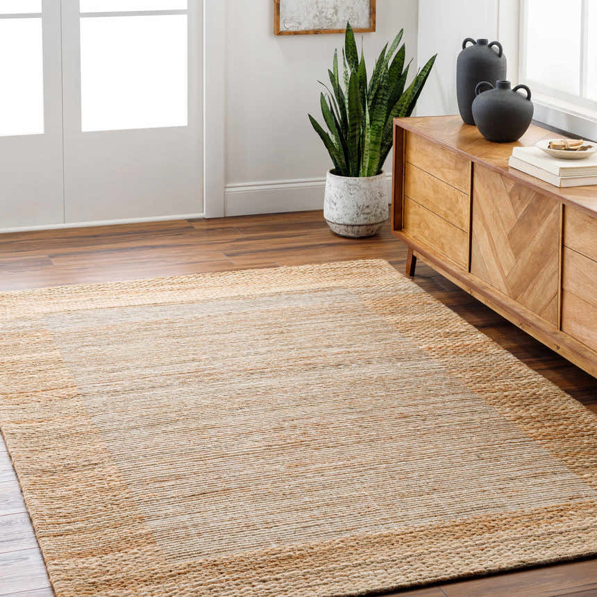 Living room scene with a lambswool and light brown Jojen Jute Area Rug, wood floors, and a mid-century modern cabinet. Roomscene-Rectangle