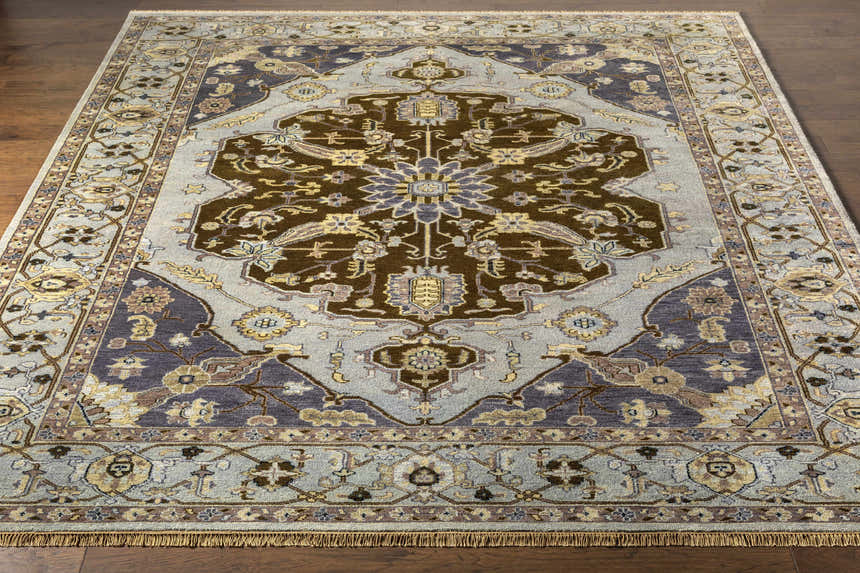 Overhead view of a rectangular Senath Area Rug in ivory, mauve, navy, olive, slate, and tan on a wood floor. Front