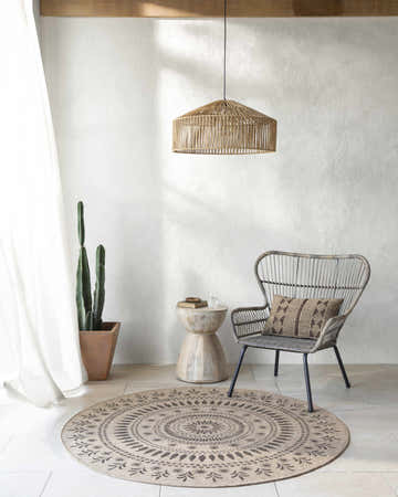 Neutral room with Beata Round Faux Jute Rug, woven chair, side table, cactus, and pendant light. Farmhouse style. Roomscene-Round