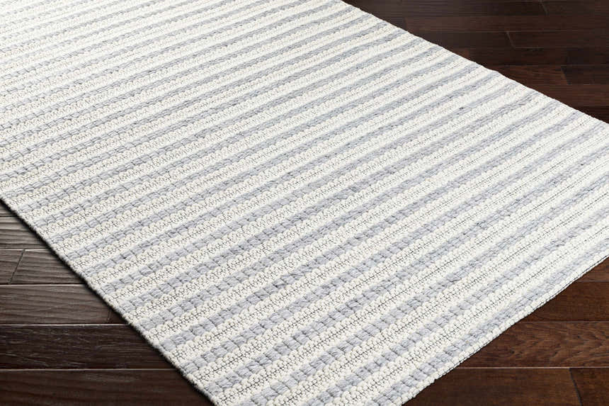 Close-up of the hand-woven Laleh Gray Area Rug showing its beige and rose cream striped pattern and textured weave. Corner