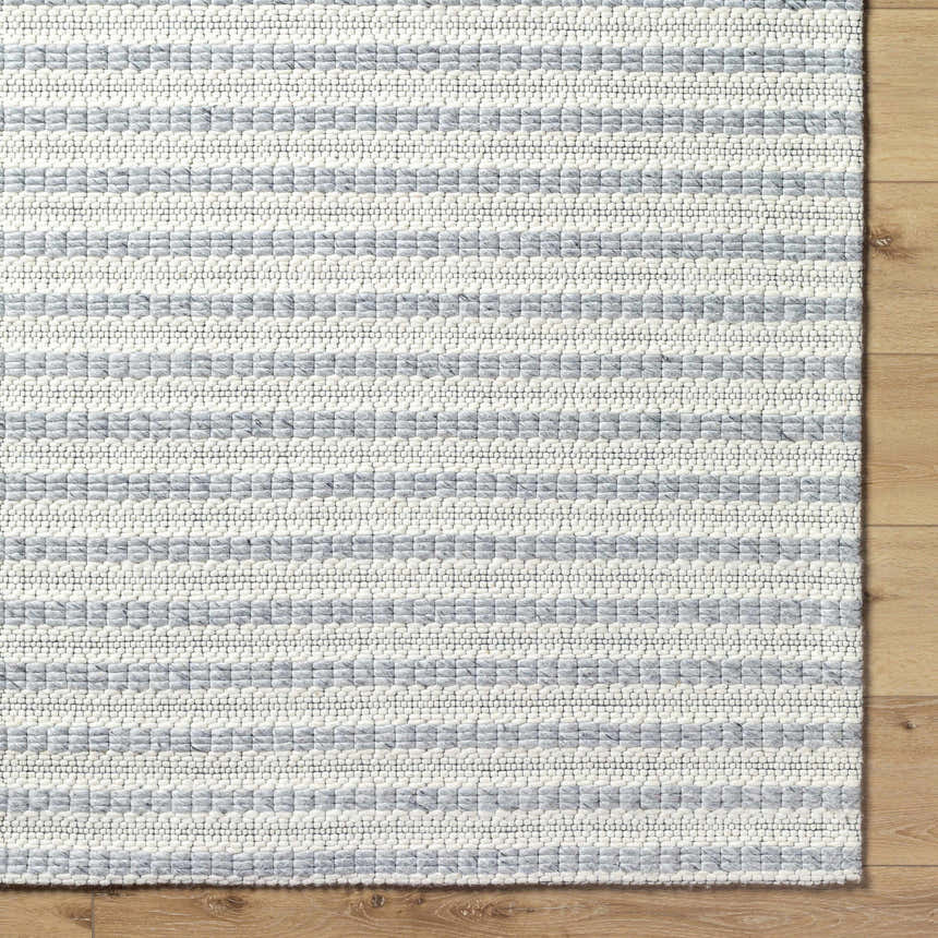 Close-up of the Laleh Gray Area Rug showing a textured, hand-woven design with beige and rose cream stripes. Corner