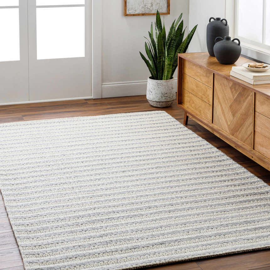 Entryway with Laleh Gray Area Rug, wood floors, and a mid-century modern console table with black vases. Roomscene-Rectangle