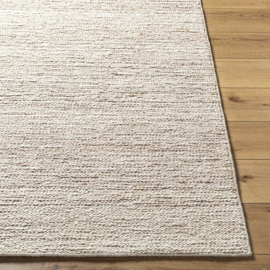 Close-up of the hand-tufted Urmat Wool Area Rug. Light silver, pearl, and warm gray tones with a subtle textured design. Front