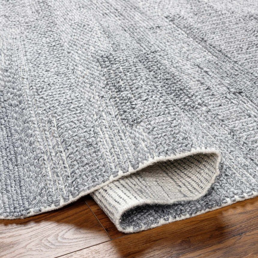 Close-up of the hand woven Chepe Area Rug, charcoal, light gray and silverton recycled yarn, contemporary style. Fold