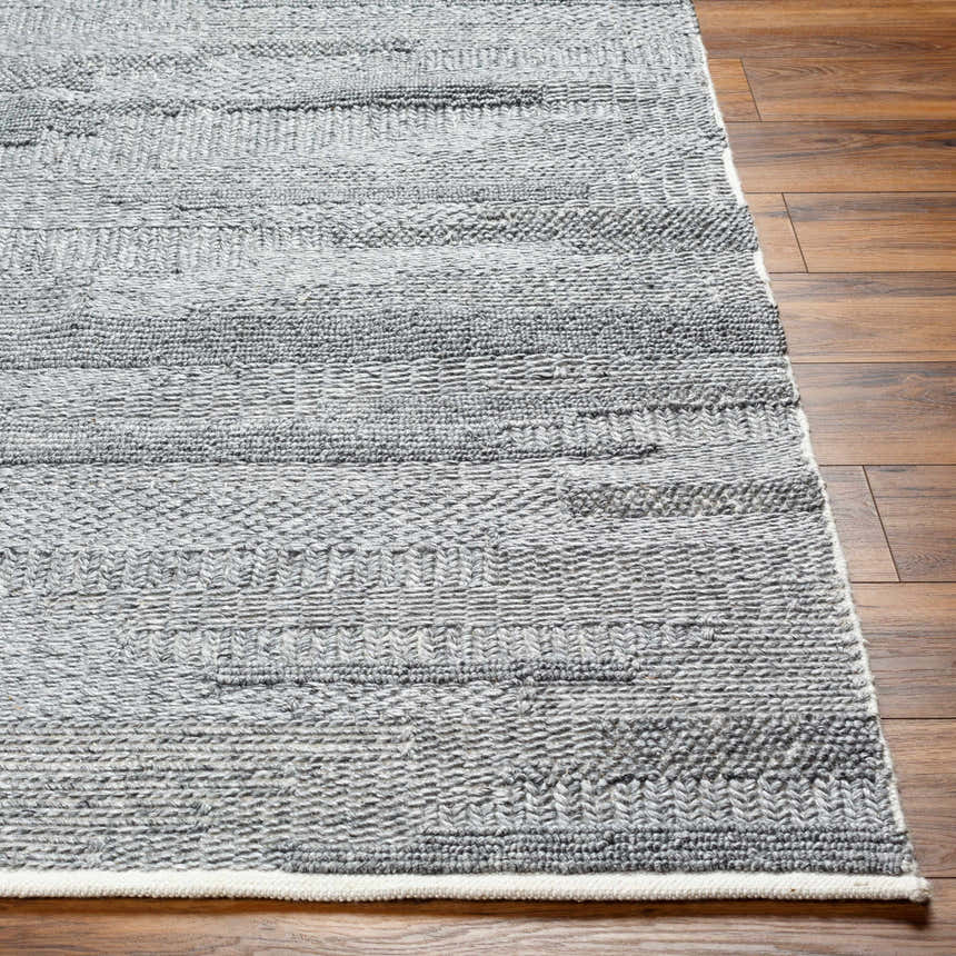 Close-up of the hand woven Chepe Area Rug. Charcoal, light gray, and silverton hues with a subtle horizontal pattern. Front