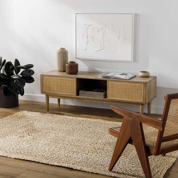 Living room scene with a tan Elkie Beige Jute Area Rug, wood media console, modern chair, and minimalist art. Roomscene-Rectangle