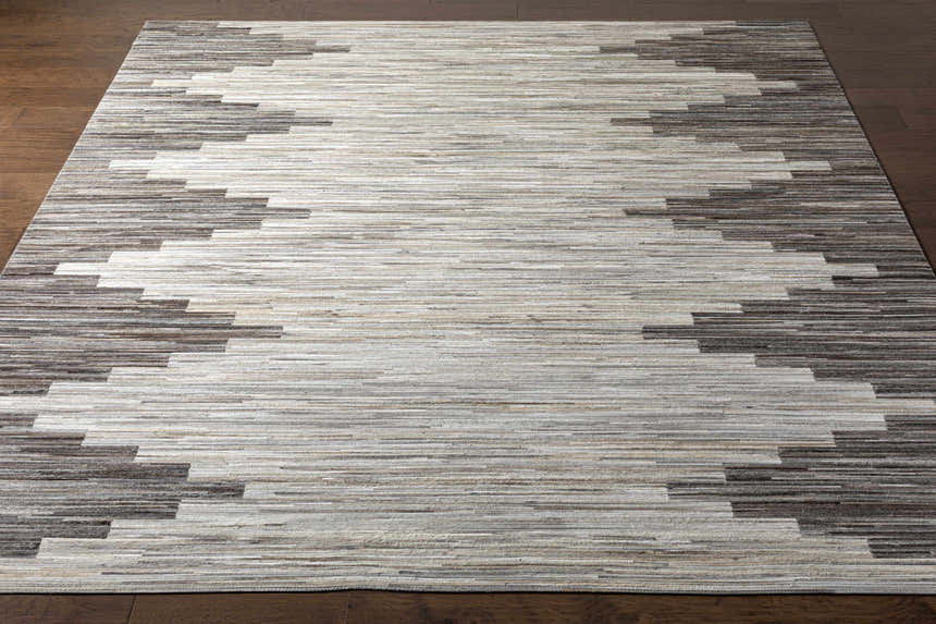 Close-up of Shearwater Premium Rug. Hand-crafted hair on hide rug in beige, charcoal, and cream with a Southwestern pattern. Front