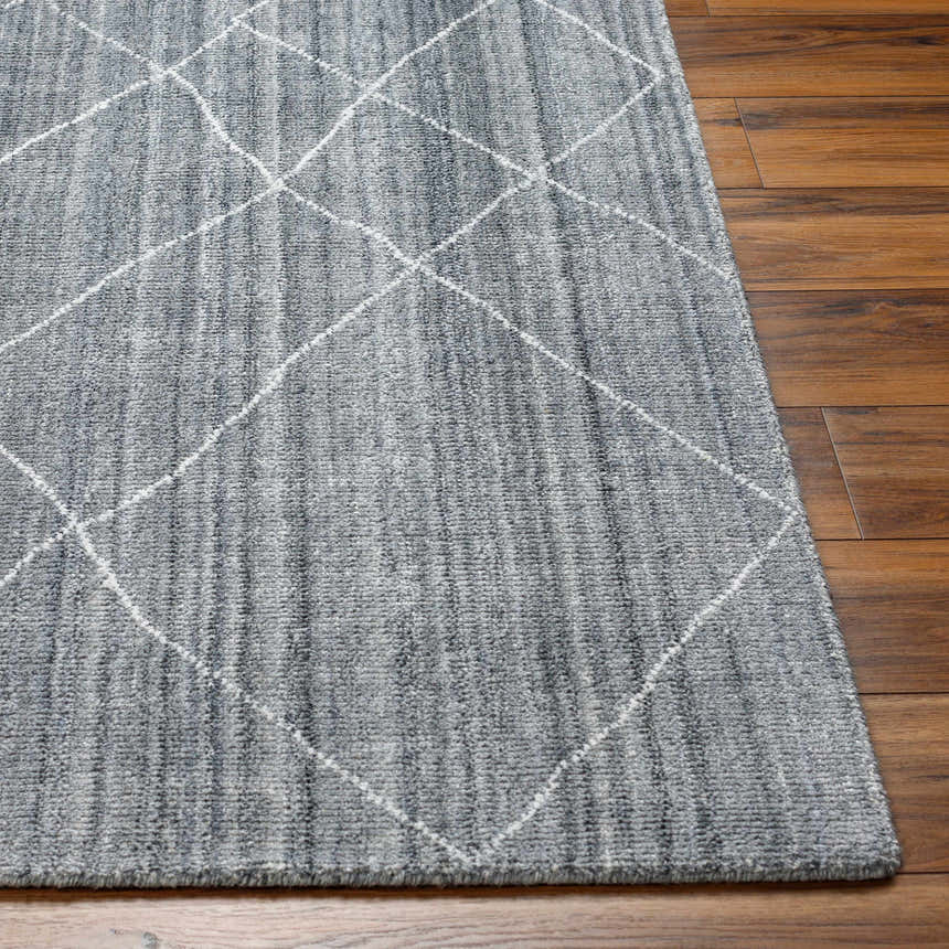 Close-up of the gray Nari Area Rug showing its diamond pattern and textured weave on a wood floor. Front