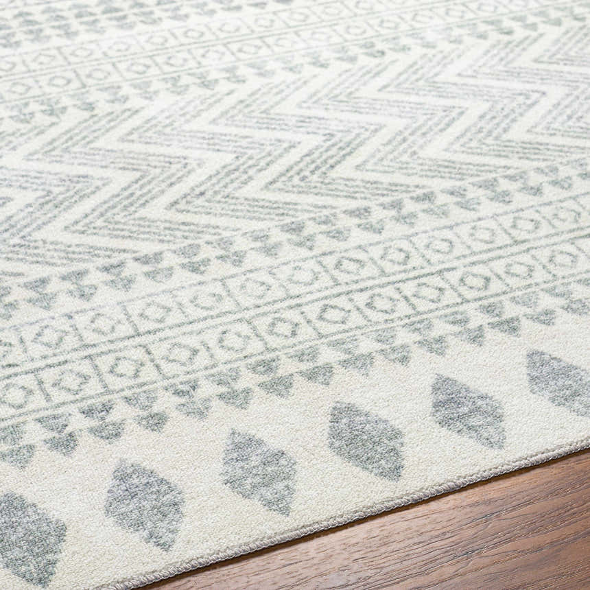 Close-up of the Danon Washable Area Rug in Arctic Stone. Features a gray geometric pattern on a soft, textured base. Texture