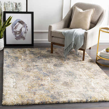 Living room scene with a Shullsburg area rug in aqua, beige, gold. Modern chair, art, and gold side table. Roomscene-Rectangle