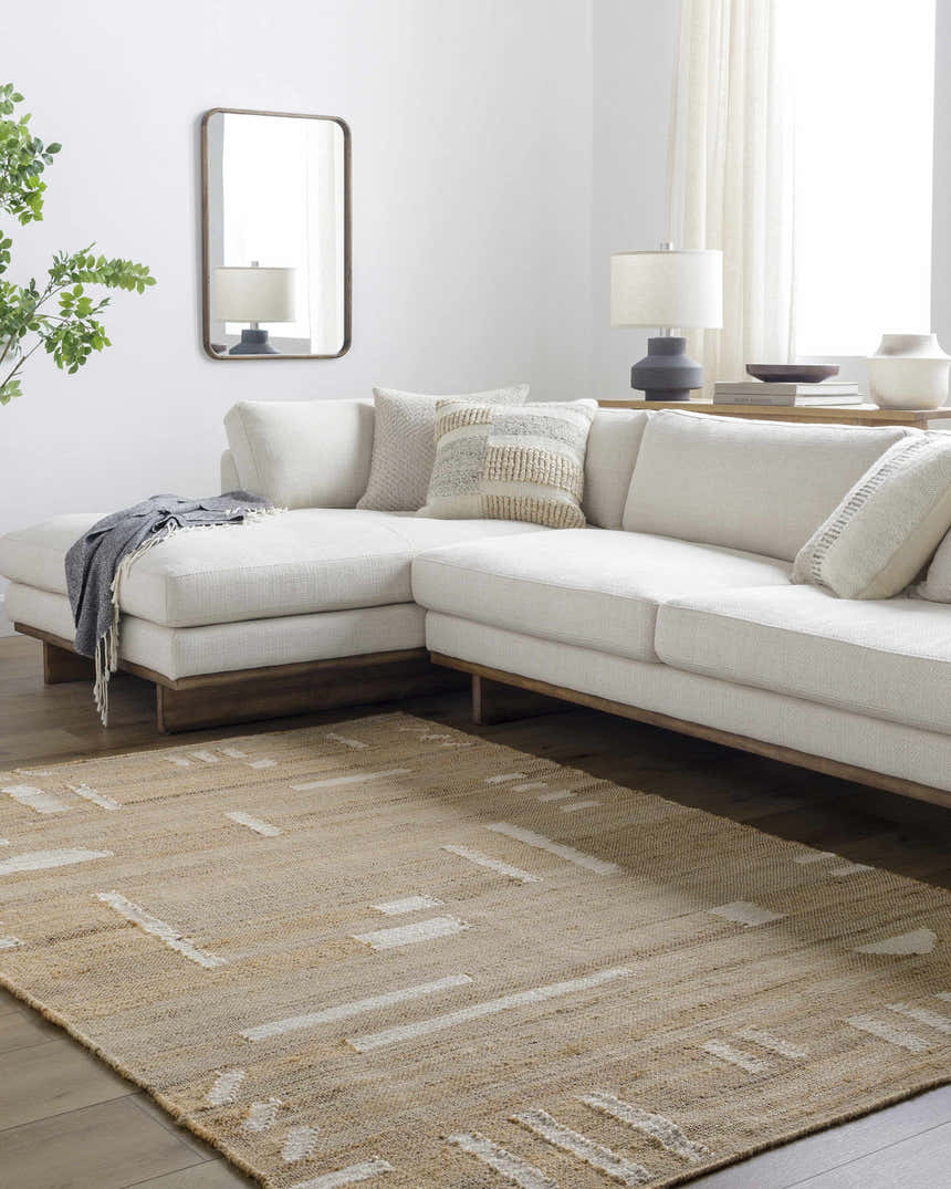 Living room scene with a cream sectional sofa and tan Sasha Jute Rug with a subtle geometric pattern. Roomscene-Rectangle