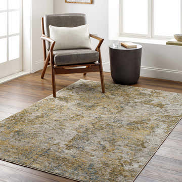 Living room scene with a gray chair on the Aleka Rich Textured Rug in bone, clay, dark gray, sage, and walnut tones. Roomscene-Rectangle
