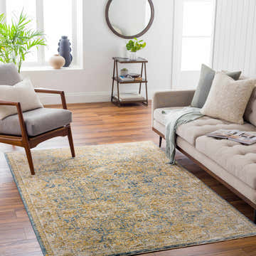 Living room scene with Ange Cream & Blue Rich Textured Rug, gray chair, and beige sofa on hardwood floors. Roomscene-Rectangle