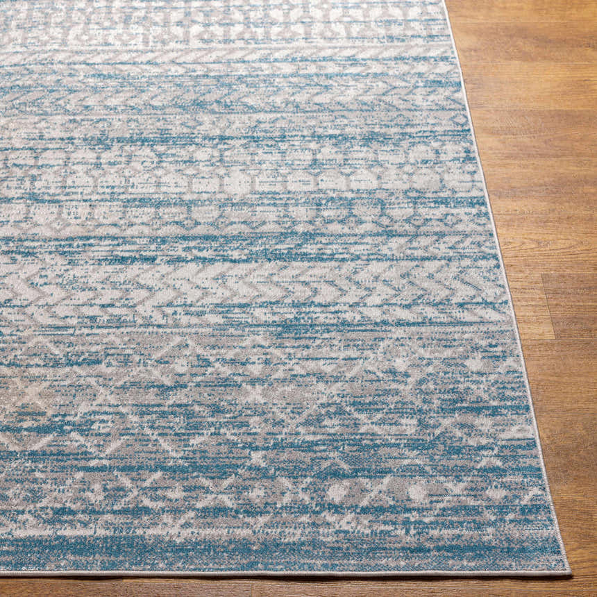 Close-up of the Tambac Blue Washable Area Rug showing its blue, gray, and light gray farmhouse-style pattern and texture. Front