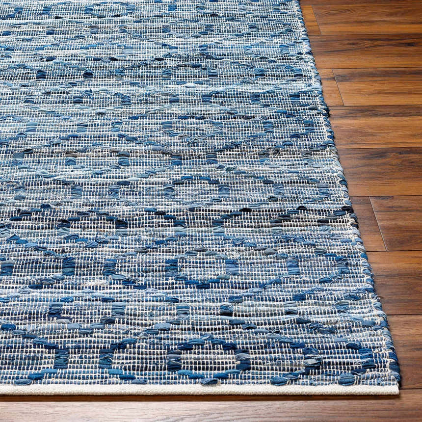 Close-up of the hand woven Gurit Blue & Brown Area Rug showing textures and shades of blue on a wood floor. Front