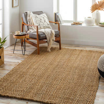 Light-filled living room with a tan Asaka Jute Area Rug, leather chair, and side table for a cozy, Scandinavian feel. Roomscene-Rectangle