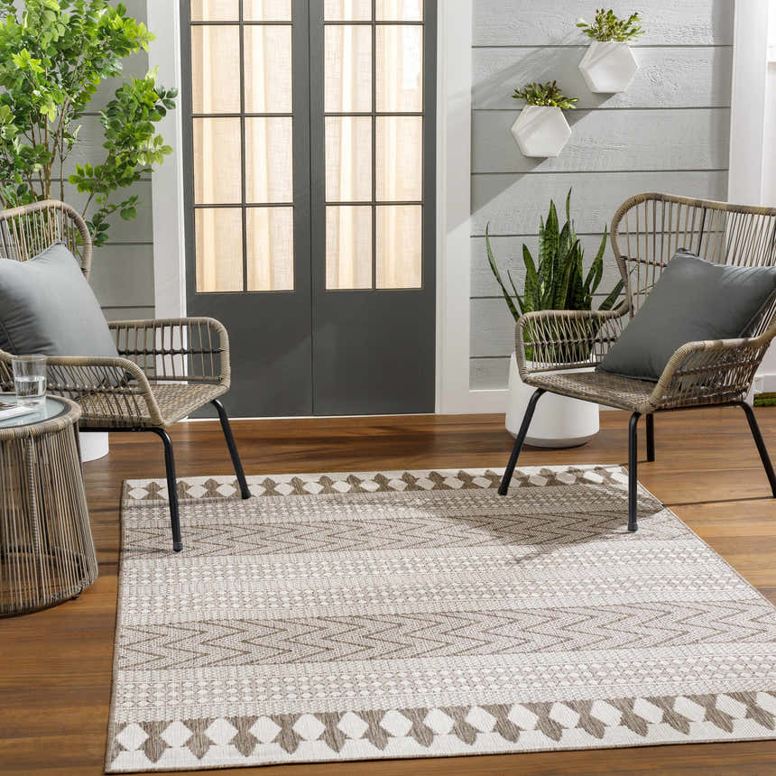 Outdoor patio scene with wicker chairs and the Asif Brown Area Rug, a farmhouse style rug with brown and off-white geometric patterns. Roomscene-Rectangle
