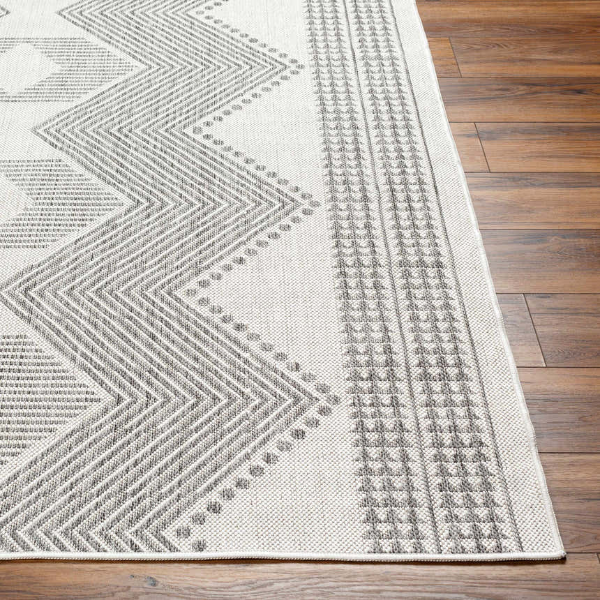 Close-up of the Evana Gray Area Rug showing a geometric zigzag pattern in light and medium gray on an off-white base. Front