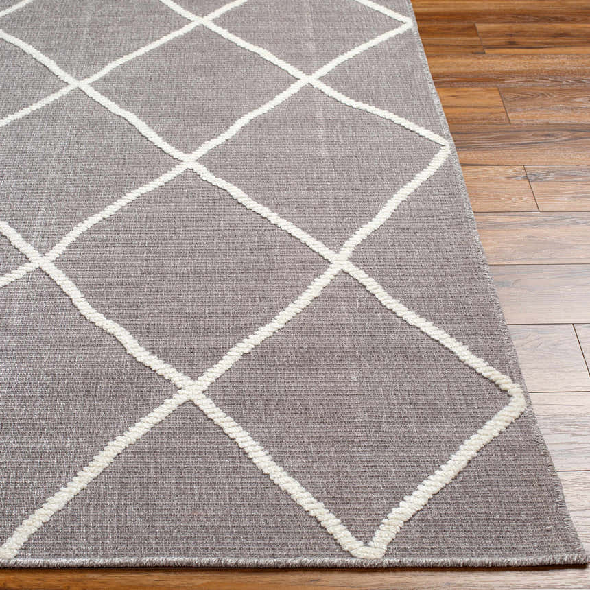 Close-up of the Amani Gray Washable Rug showing its geometric diamond pattern and soft texture on wood floors. Front