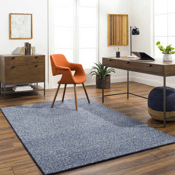 Home office with wood desk, orange chair, and Alyra Blue Solid Area Rug on wood floor. Roomscene-Rectangle