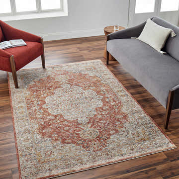 Living room scene with Aman Rust Area Rug, brick red chair, and gray sofa on wood floor. Roomscene-Rectangle