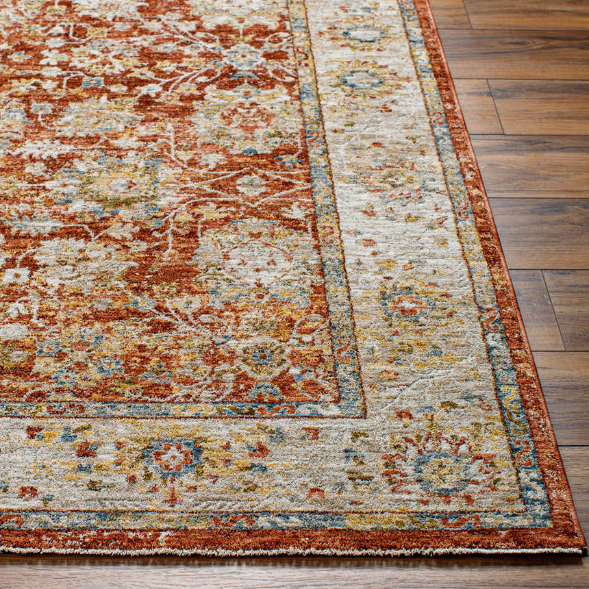 Close-up of the Duong Rust Textured Rug showing its brick red, sage, and mustard floral pattern and soft texture. Front